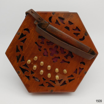End of concertina showing cutout wood, buttons  and leather handle 