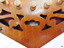 Close-up of cutout wood showing crimson fabric below it