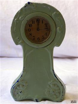 Small green coloured ceramic clock case with gold-tan clock face