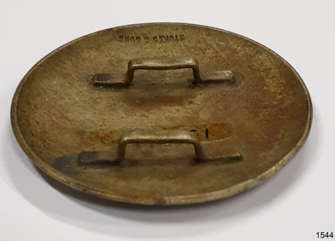 Two loops through which a strap would be threaded. Embossed maker's name.