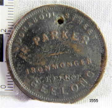 Round medallion with embossed inscription and design, and a formed hole