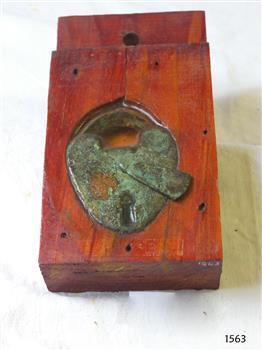 Padlock is embedded in a block o timber and sealed with resin