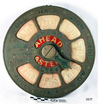 Metal dial with inlaid red sections. Text is on both the metal and the inlaid parts.
