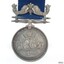 Silver metal hangs from a silver bar with a fleur de lies between two fish. Text surrounds a variety of images.