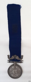Obverse of silver medal suspended on blue ribbon