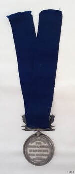 Reverse of silver medal hung from blue ribbon