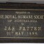 Dark coloured lid has gold embossing; rectangular frame with six rows of text explaining contents