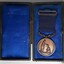 Case is hinged in centre and is lined in blue fabric with a sheen. Medal on left side is showing front surface.