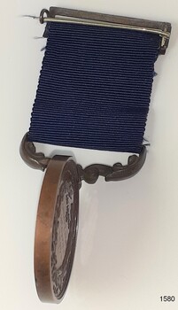 Medal is swivelled to show the edge, which is smooth.