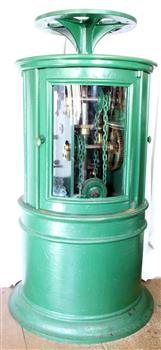 Round green metal cabinet with a wheel on top, glass doors, and mechanical equipment inside.
