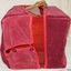 Crimson fitted cloth cover has button and loop closure.