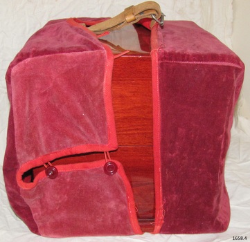 Crimson fitted cloth cover has button and loop closure.