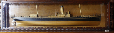 Wooden ship model in wood and glass case with decorate front frame