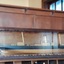 Glass fronted case has decorative border and carved wooden side decoration
