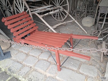 Trolley's base is at an angle and has one wheel as in a wheelbarrow. 