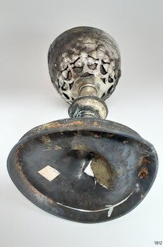 buckled base has a white sticker. Underside of bowl has decorative cut metal pattern.