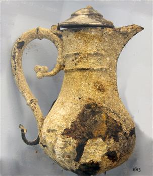 Cruet with heavily encrusted surface. Surface is corroded. 