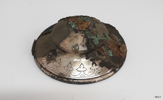 Two-thirds of the dome shaped lid is covered by encrustations