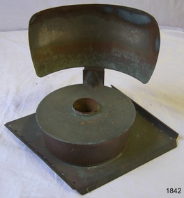 Metal lamp reservoir and reflector on a square base.