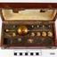 Open rectangular wooden case with brass weights and instruments inside