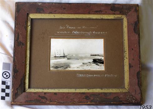 Timber framed photograph of a sailing ship stranded close to shore