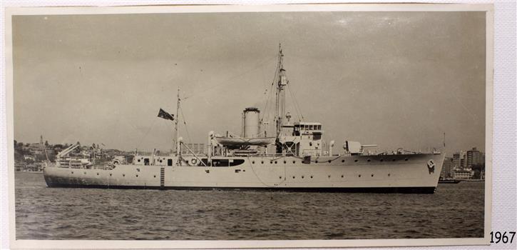 Steamship flying dark coloured flag with Union Jack and Star. Lifeboat suspended above centre of deck.