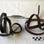 Leather straps with buckles and holes, joined to a metal oval ring with a short rod each end