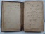 Two page spread of inside of front cover with black handwritten inscriptions on both pages