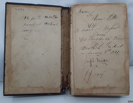 Two page spread of inside of front cover with black handwritten inscriptions on both pages