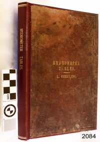 Burgandy and brown hard cover book titled "Tables for Ascertaining The Strength of Spirits"
