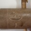 Oval with letters and symbol between the letters, impressed on cap