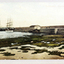 Tinted postcard of the Warrnambool Breakwater showing docked vessels, small buildings and the beach.