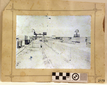 Sepia photograph, mounted, with the large steam crane on a construction site