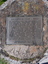 Impressed rectangular metal plaque mounted on concrete 