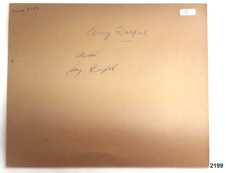 Rear of photograph has inscriptions (incorrect ship name) and sticker