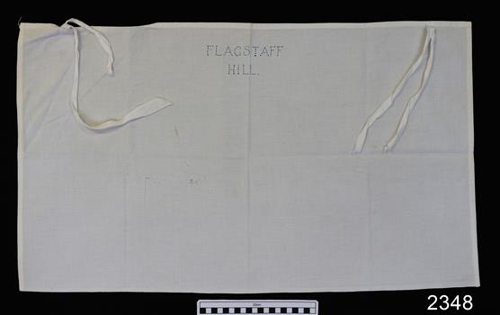 White cotton bag with tape closure and blue silk embroidered on the bax