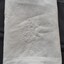 White embroidered motif near the cloth's hem