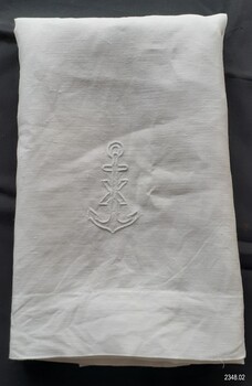 White embroidered motif near the cloth's hem