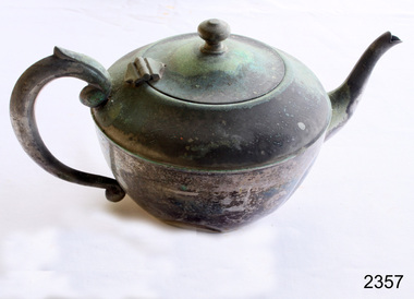 Metal teapot with hinged lid. Dented on the side. Heavy oxidation.