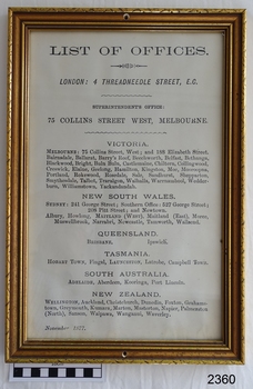 Gilt framed document with printed text . Frame has a hole in top and bottom centre of frame.
