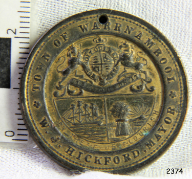 Medal has coat of arms and images with text around the edge