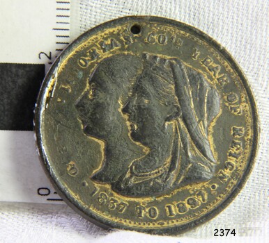 Medal has two co-joined female portraits looking left, with text around edge