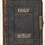 Front cover of black leather with embossed gold title and impressed line and motif decoration