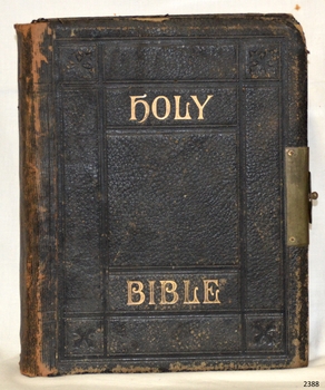 Front cover of black leather with embossed gold title and impressed line and motif decoration
