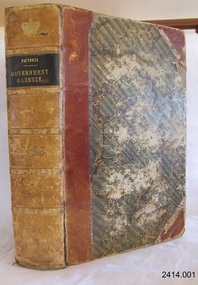 Hard covered bound book with patterned cover and leather spine with gild embossed title