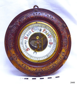 Barometer in decorative, carved wooden frame