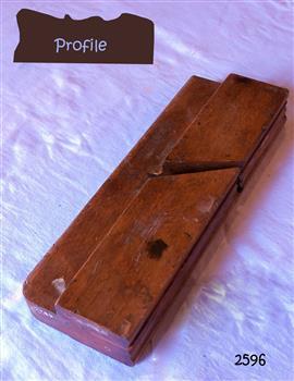 Wooden plane without blade. Remnants of dark and light paint splashes