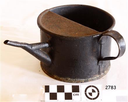  A slightly rusty metal ink kettle or jug with a spout, and a handle on the side.