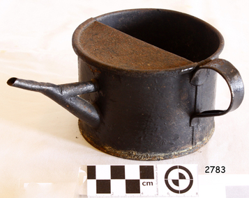  A slightly rusty metal ink kettle or jug with a spout, and a handle on the side.