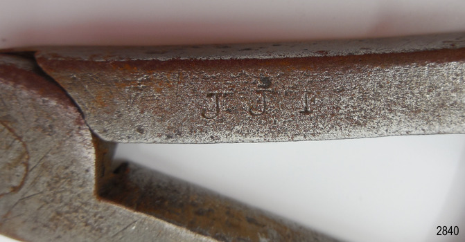 Inscription is stamped into the top of the compass' arm